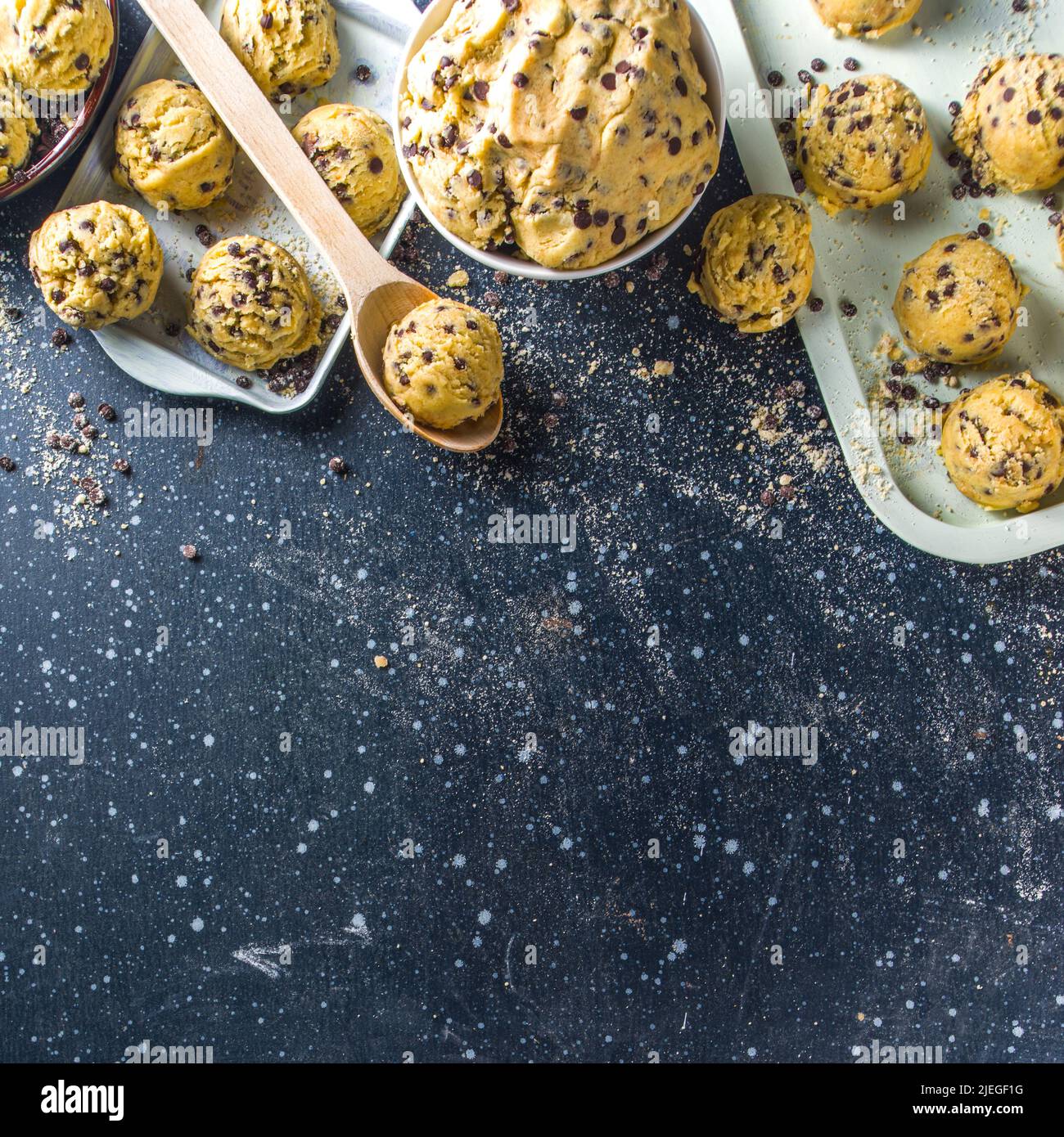 https://c8.alamy.com/comp/2JEGF1G/edible-raw-dough-american-dessert-edible-raw-cookie-dough-with-chocolate-drops-in-small-bowl-and-on-baking-sheets-dark-blue-background-copy-space-2JEGF1G.jpg