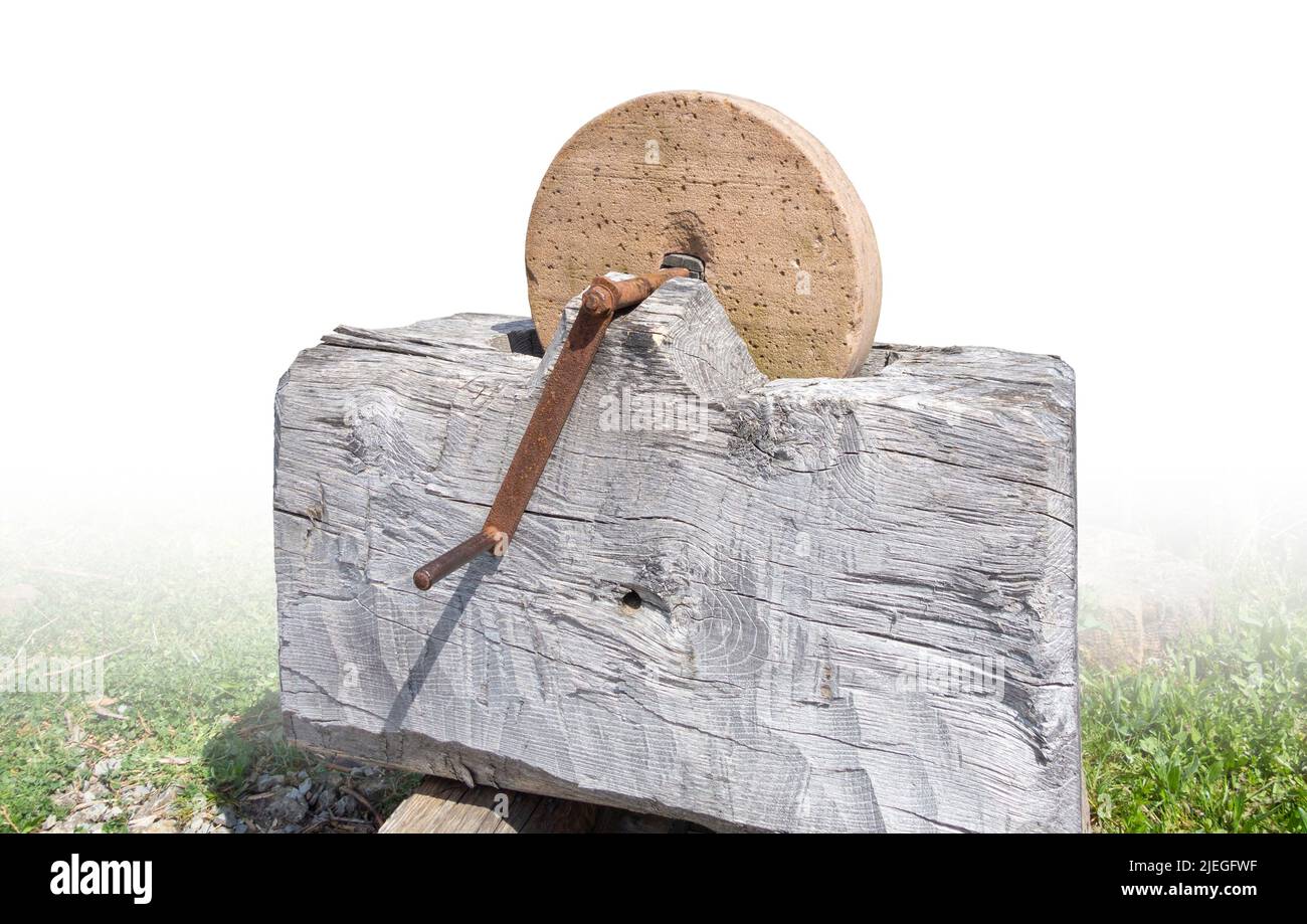Medieval sharpening stone in sunny ambiance partly isolated in white back Stock Photo