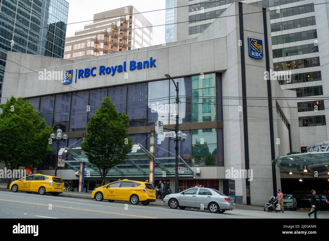 RBC Royal Bank building with cars parking on the side of the road in downtown Vancouver, BC