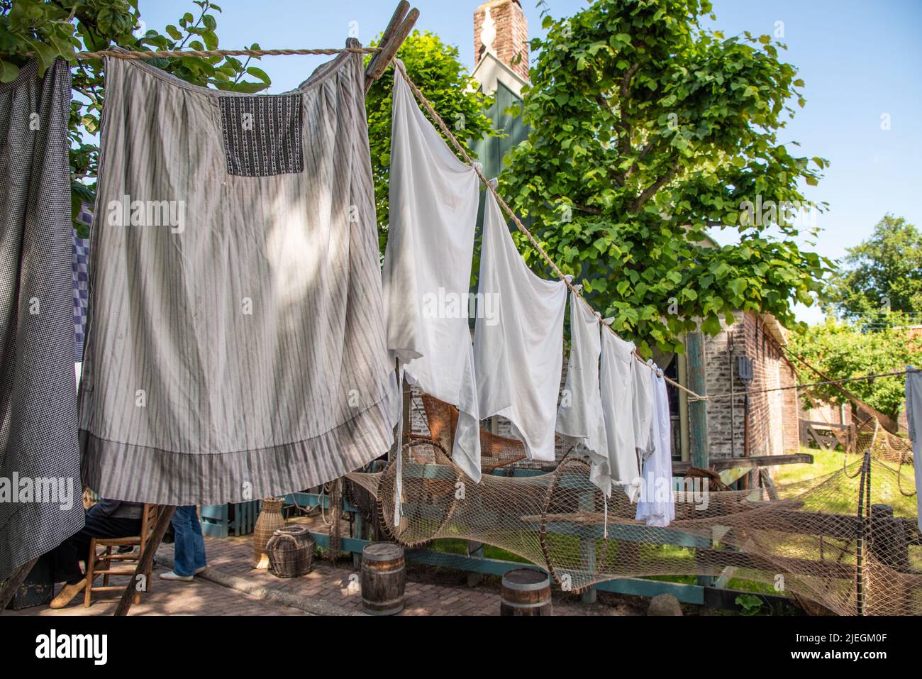 Enkhuizen, Netherlands. June 2022. Talking fishermen men and women and the backdrop of drying laundry. High quality photo. Selective focus. Stock Photo
