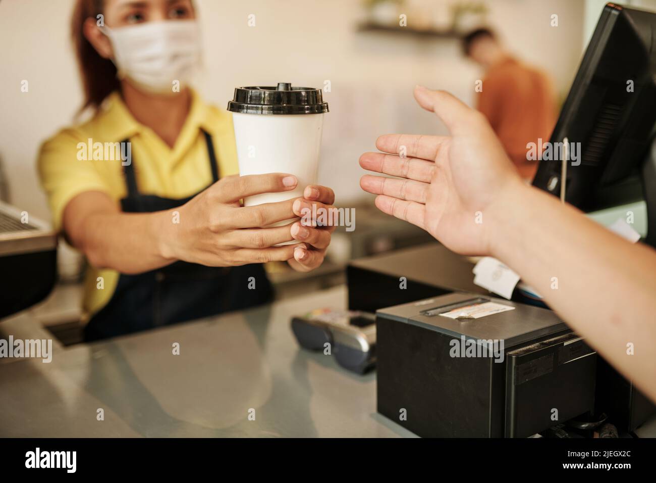 barista wearing medical mask when selling cup of take out