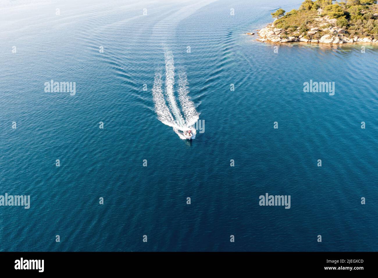 Motorboat, speed boat navigating on rippled sea background, white wake. Summer vacation in Aegean Sea Greece. Aerial drone view Stock Photo