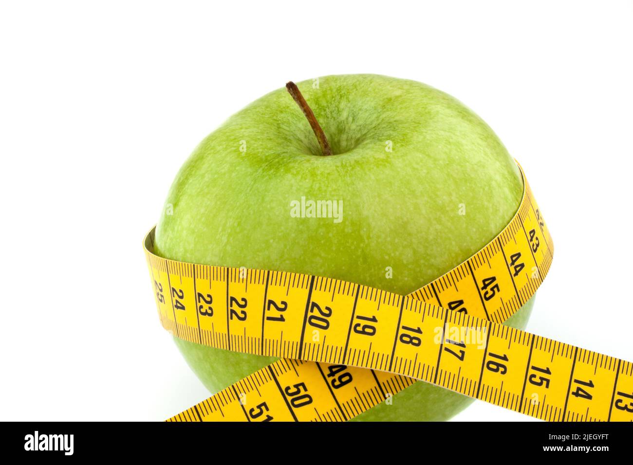 Ein grüner Apfel mit Massband. Symbol für Diät, Abnehmen mit Obst, Stock Photo