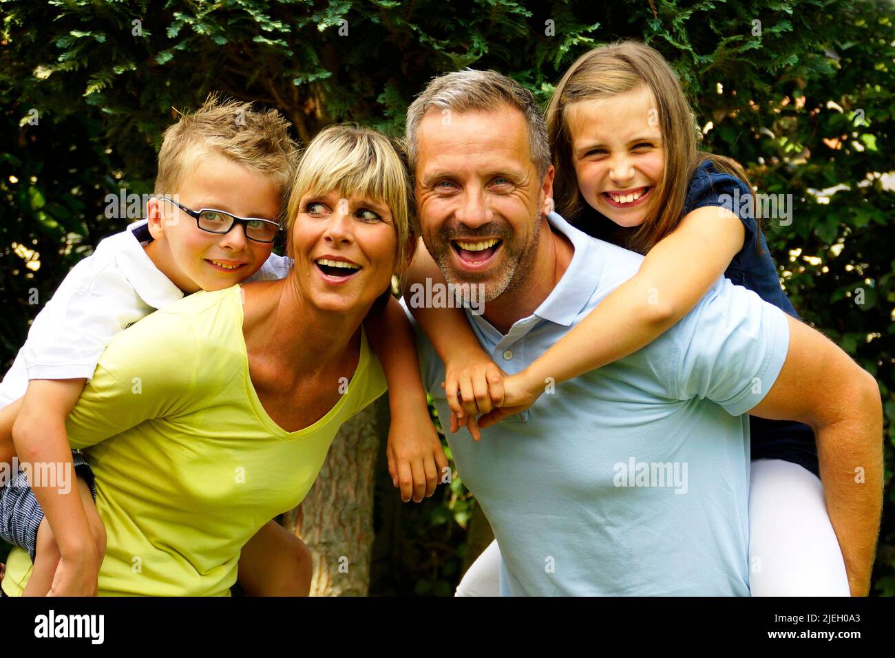 Eine glückliche Familie im Garten, 4 Personen, Mann, Frau, Sohn und
