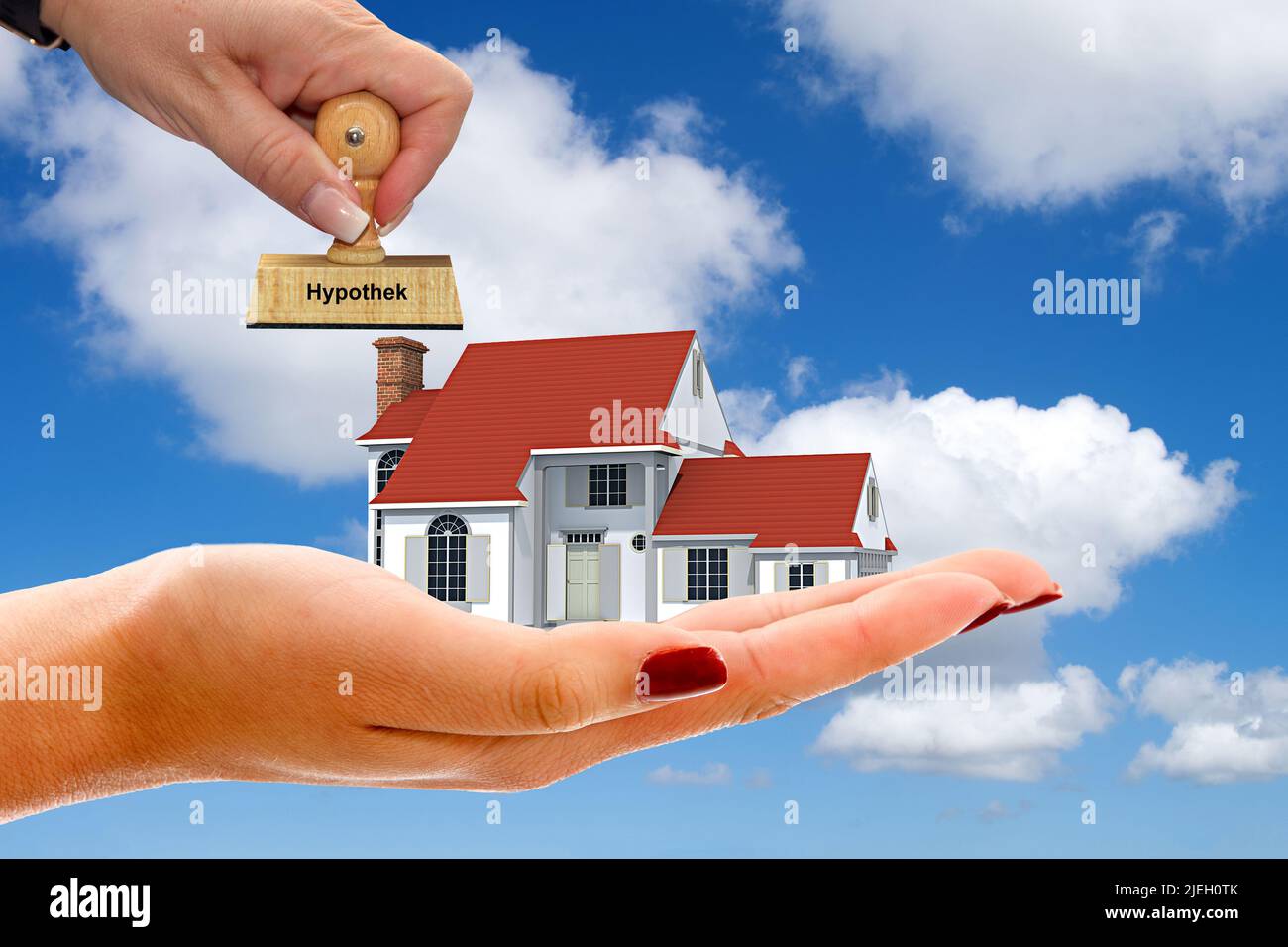 Hand mit Einfamilienhaus, Cumulus Wolken, blauer Himmel, Fruehling in Norddeutschland, Wunschhaus, Traumhaus, Baufinanzierung, Kredit, Stempel, Hypoth Stock Photo
