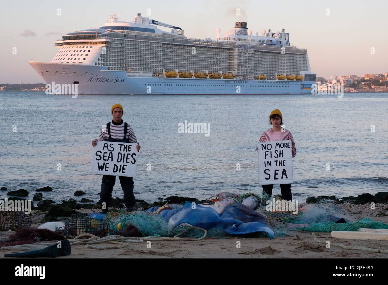 Lisbon, Portugal. 27th JUN 2022. Members of Ocean Rebellion perform a creative theatrical action where Dead Merfolk are washed-up at dawn, caught in a trawler-net along with debris from the sea (both plastics and seakill). Ocean Rebellion demands the UN calls for an end to all national fuel subsidies to fishing fleets and bans bottom trawling on the grounds of both needless biodiversity loss, through bycatch, and blue carbon release. Credit: Dan Pearson/Alamy Live News Stock Photo