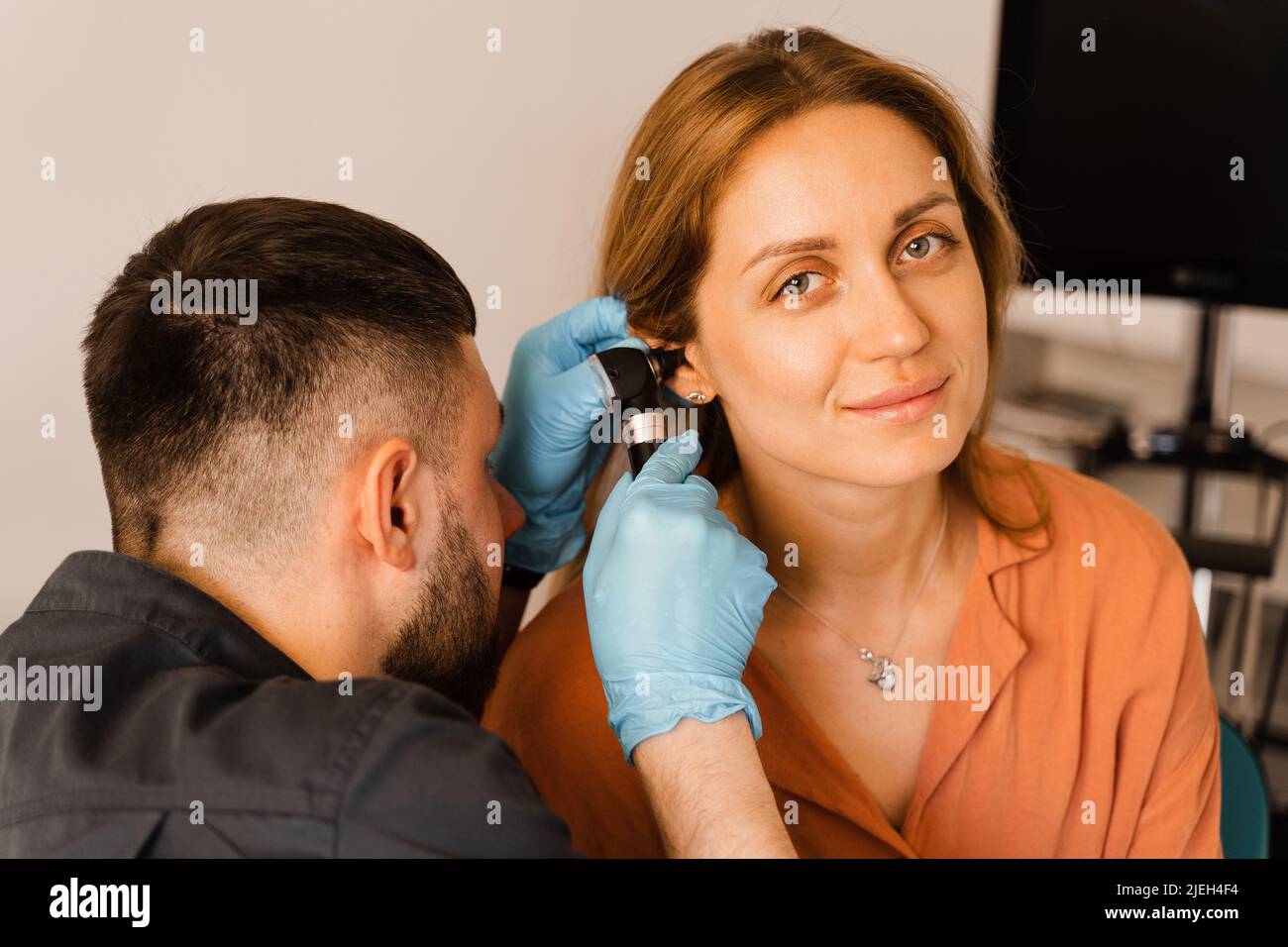 ENT doctor with otoscope. Otoscopy. Otolaryngologist looks through