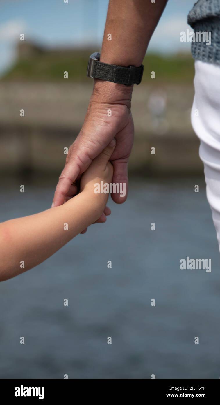 mother holding hand of small child Stock Photo