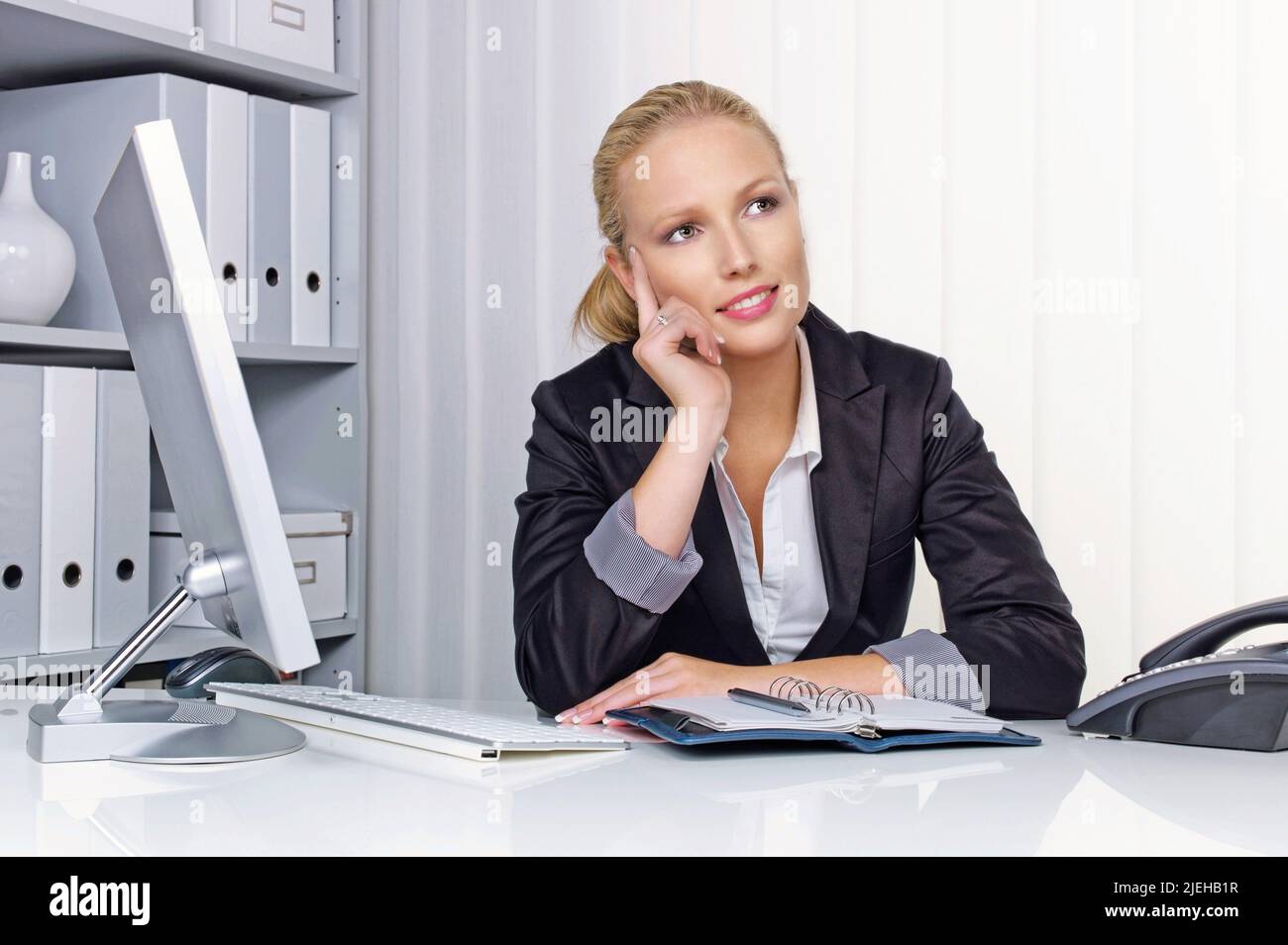 Eine junge, erfolgreiche Geschäftsfrau sitzt an ihrem Schreibtisch im Büro Stock Photo