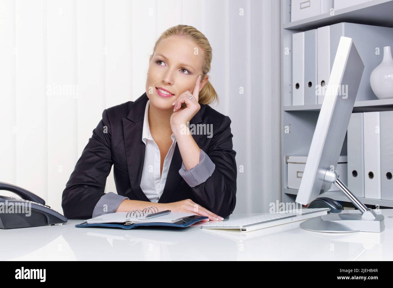Eine junge, erfolgreiche Geschäftsfrau sitzt an ihrem Schreibtisch im Büro Stock Photo