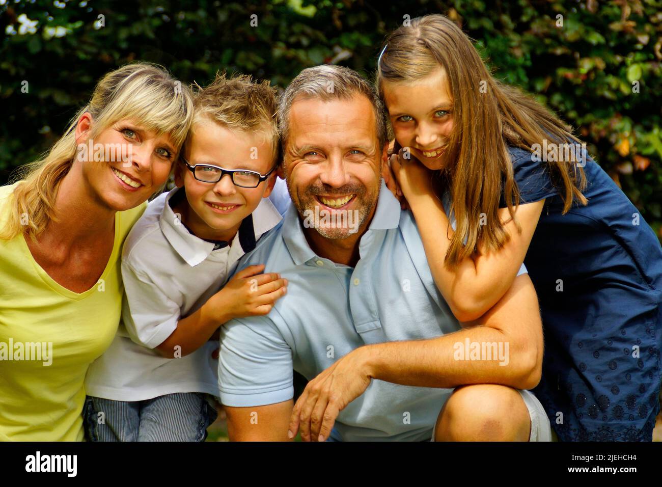 Eine glückliche Familie im Garten, 4 Personen, Mann, Frau, Sohn und Tochter, 45, 50, 4, 7, Jahre, Stock Photo