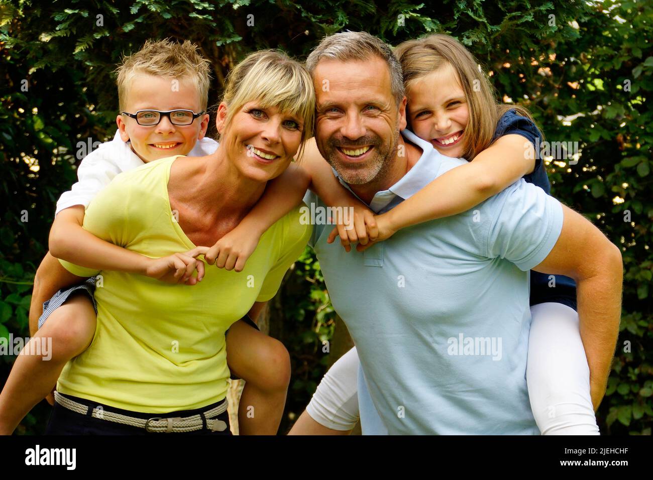 Eine glückliche Familie im Garten, 4 Personen, Mann, Frau, Sohn und Tochter, 45, 50, 4, 7, Jahre, Stock Photo