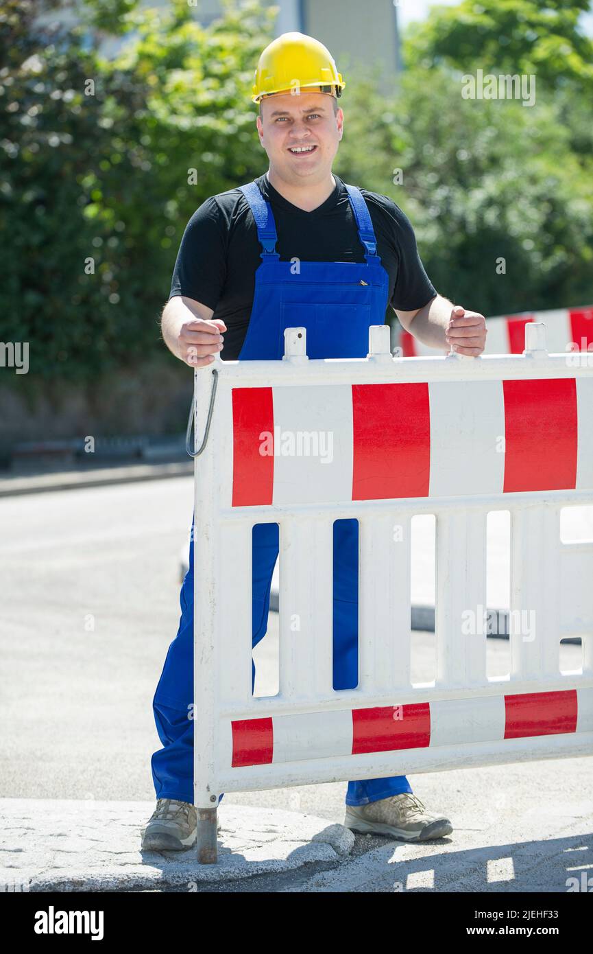 Arbeiter überprüft die Baustellenabsperrung , gelber schutzhelm, Mann, 35, 40, Bauarbeiter, beruf, Berufe, Stock Photo