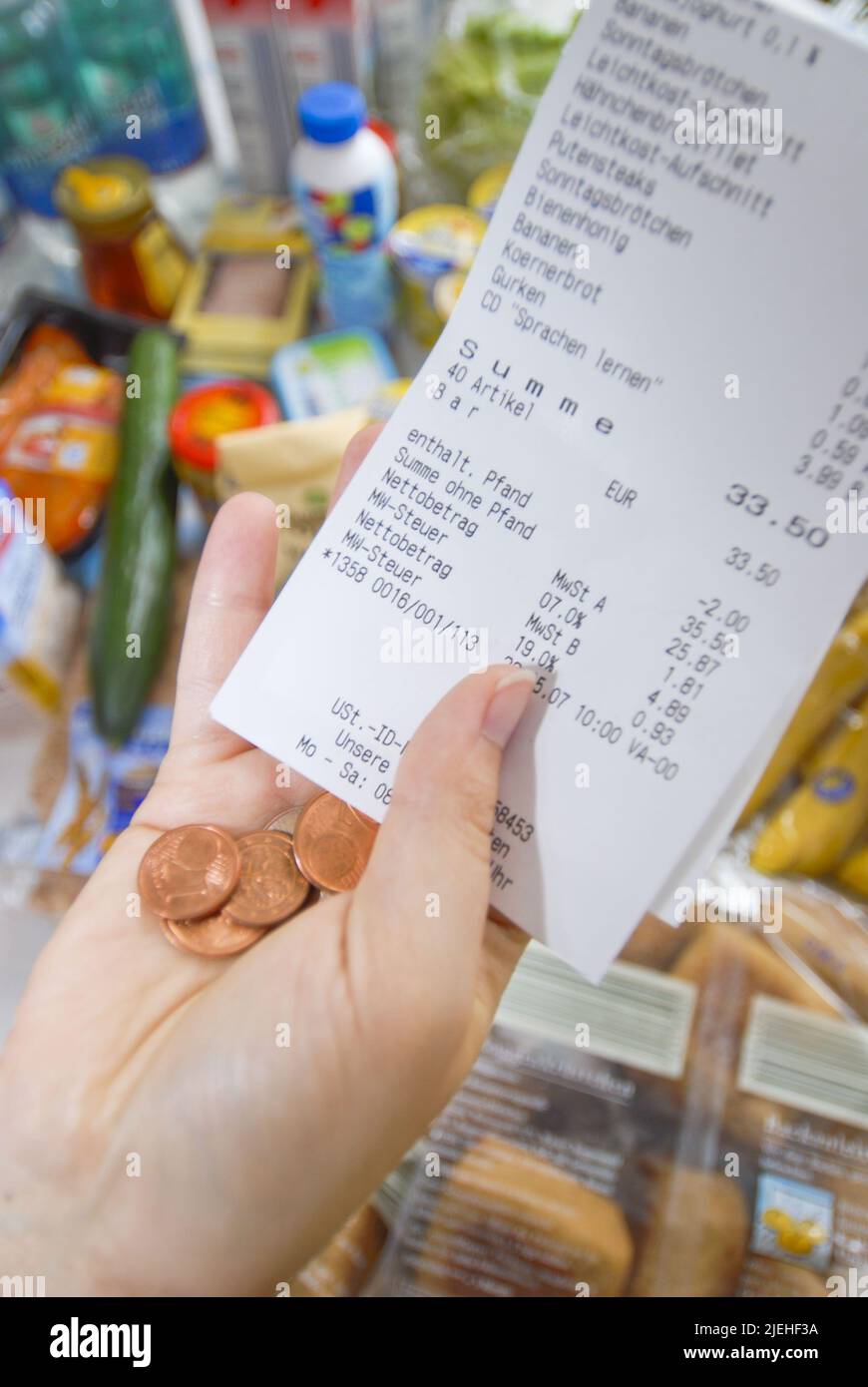 Einkaufen wird immer teuer, Preissteigerung bei Lebensmittel, Frau kontrolliert Geld in der Geldbörse und vergleicht den Kassenbon, Stock Photo