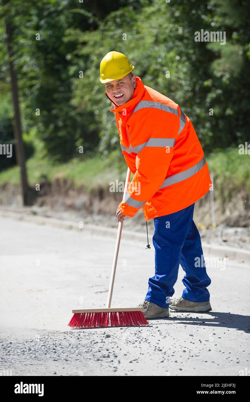 Arbeiter mit Straßenbessen, Bauarbeiter, Beruf, Berufe, 35, 40, Jahre, Warnweste, gelber Schutzhelm, Stock Photo