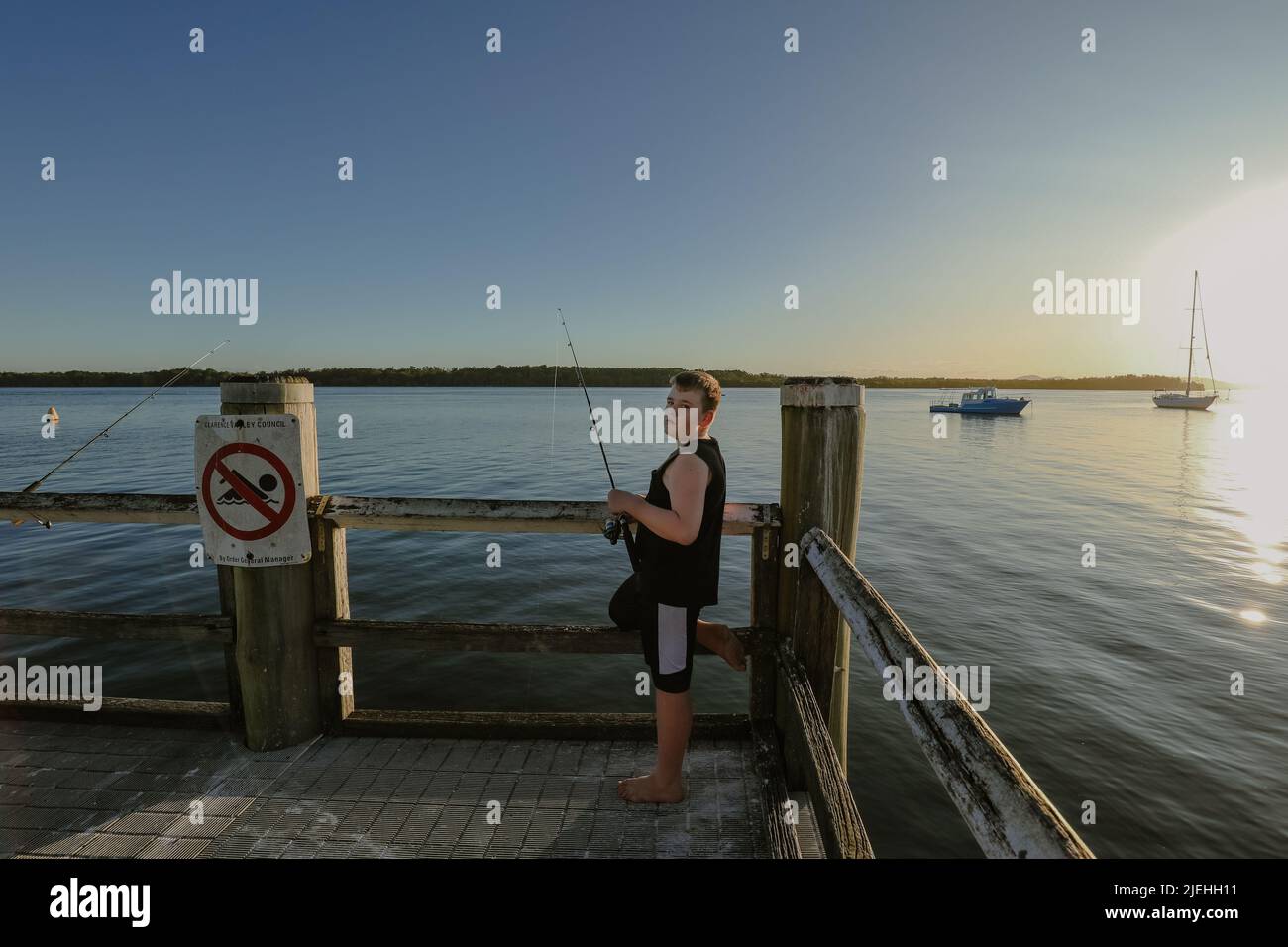 Boy fishing on jetty at Iluka, NSW Australia Stock Photo Alamy