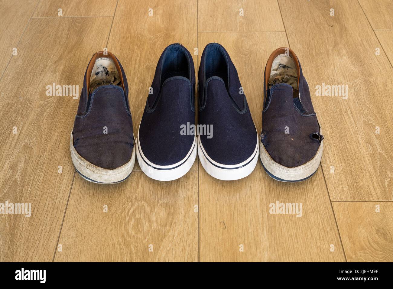 Stark comparison - blue and white shoes - new versus old and worn - inequality Stock Photo