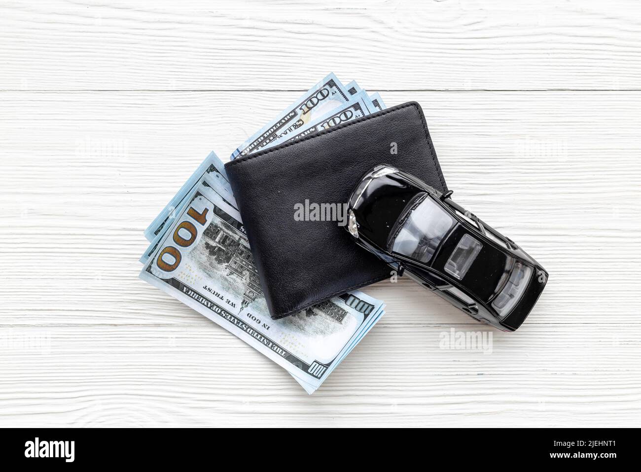 Purchase or rent a car concept. Toy car with wallet and money cash