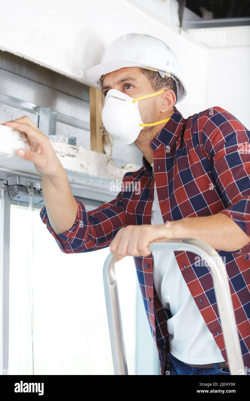 environmental abatement worker hangs lead hazard caution sign Stock