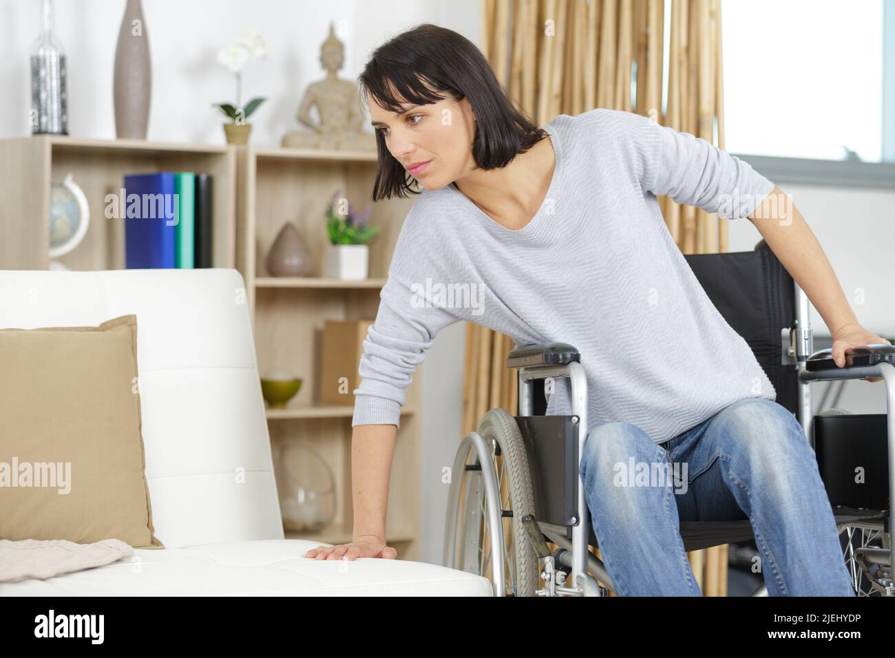 woman transferring from wheelchair to the sofa Stock Photo Alamy