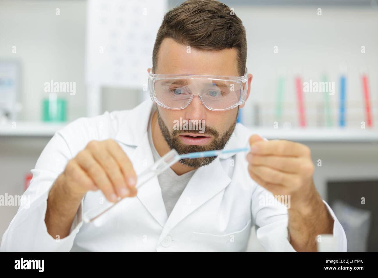 young scientist pipetting blue liquid into test tubes close up Stock ...