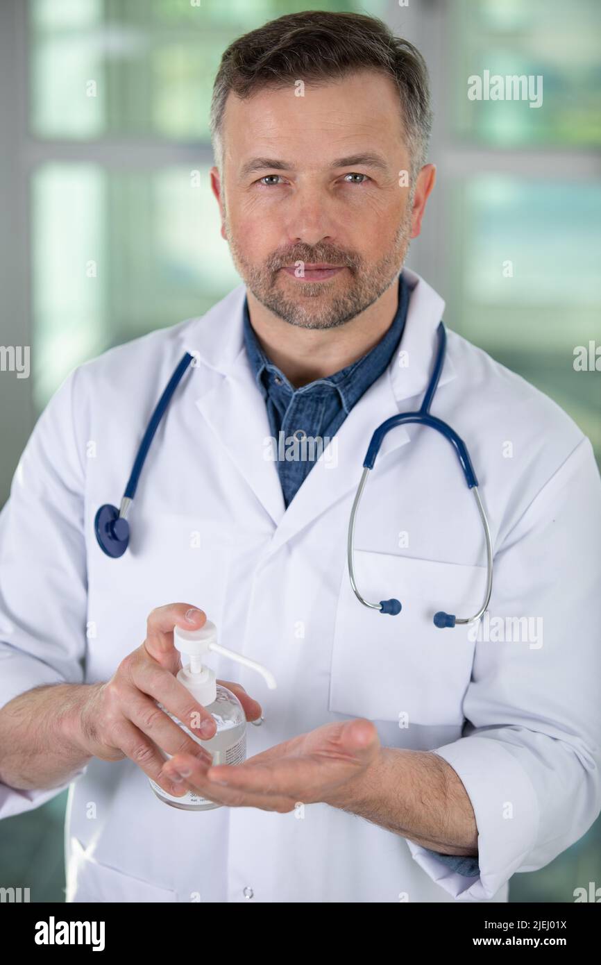 doctor dispensing sanitiser into his hand Stock Photo Alamy