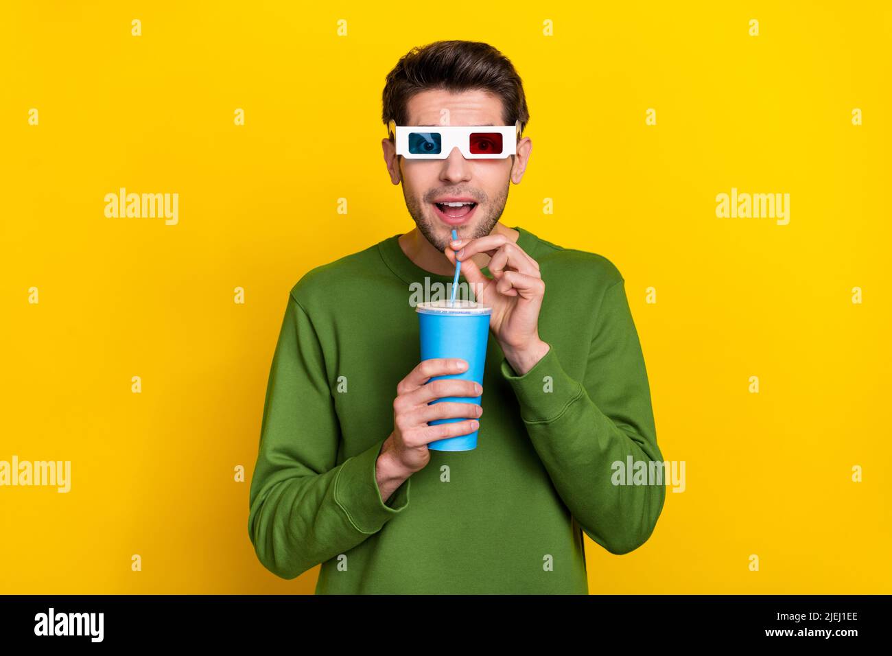 https://c8.alamy.com/comp/2JEJ1EE/photo-of-excited-funky-young-guy-wear-green-sweater-watching-3d-movie-drinking-soda-isolated-yellow-color-background-2JEJ1EE.jpg