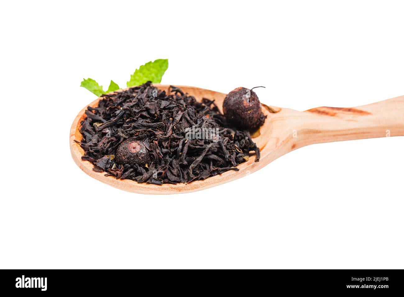 Premium red tea with berries of black currant. Pile of black tea in a wooden spoon. Assortment of tea in shop. Chinese or oriental healthy, warming te Stock Photo
