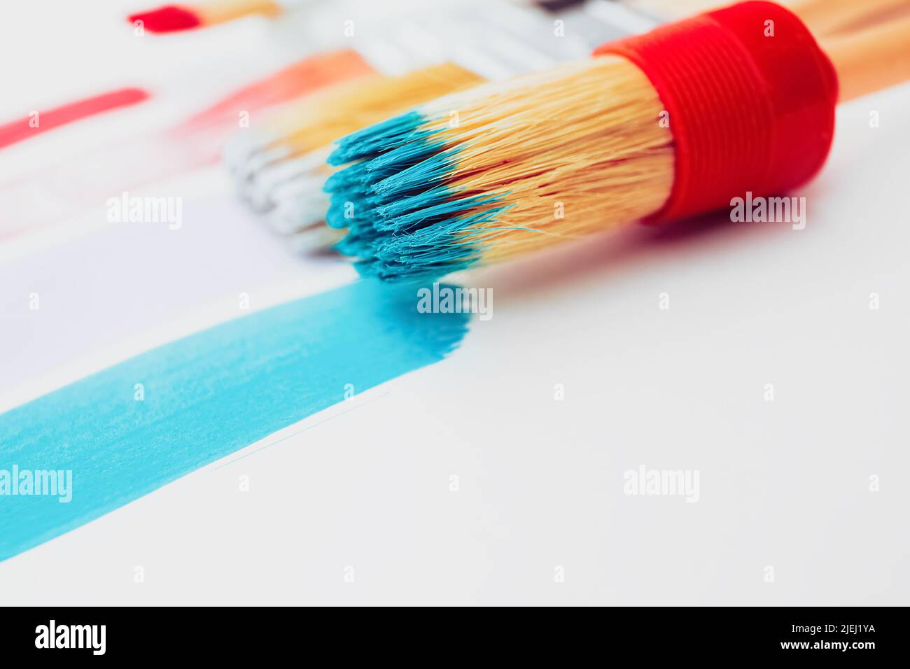 Artistic background. Paintbrushes are painting colorful brushstrokes on light background. Trendy pastel pink and mint colors of paint strokes. Mockup, Stock Photo