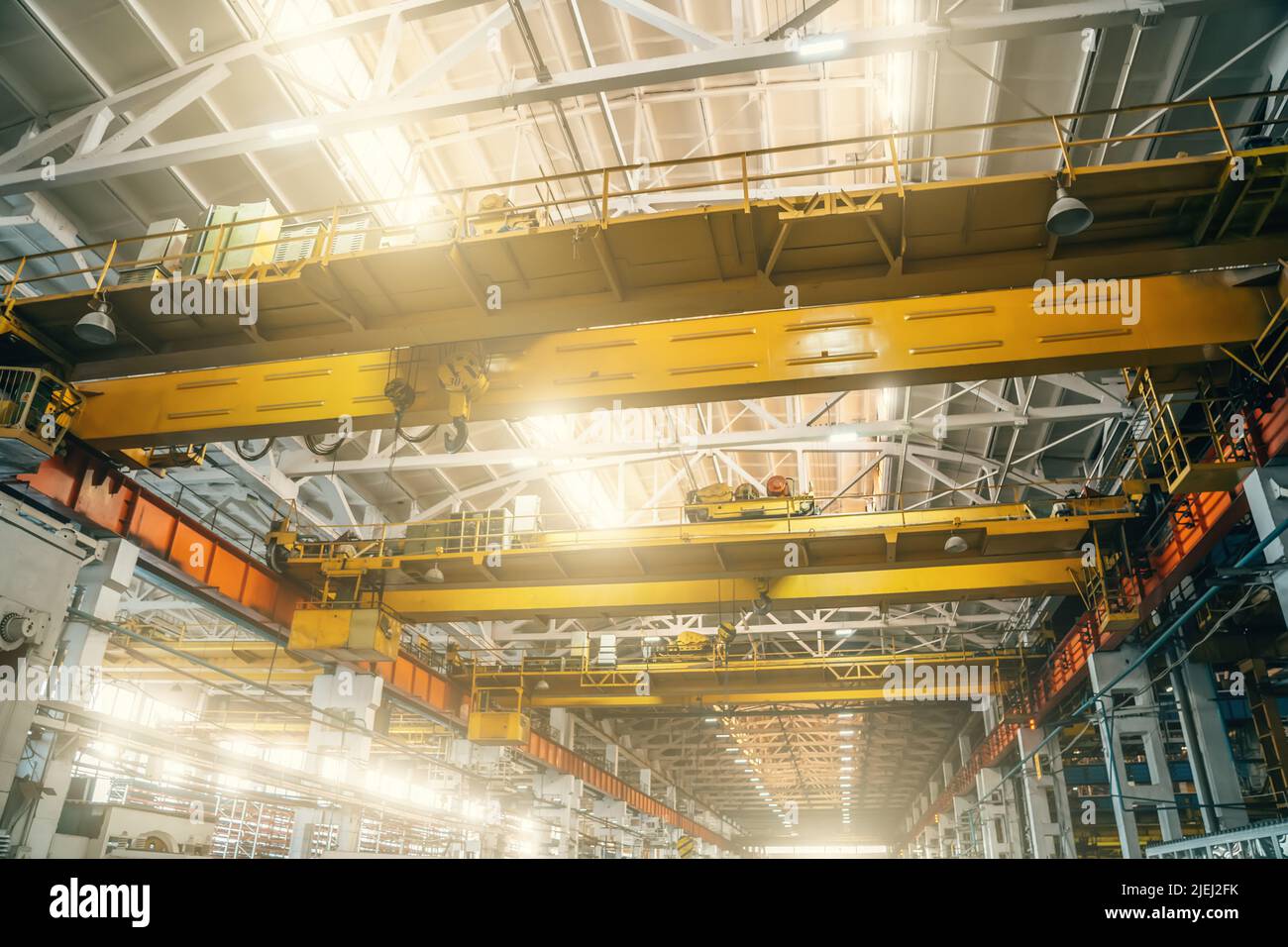 Yellow overhead or beam or bridge cranes in industrial metalworking factory. Stock Photo