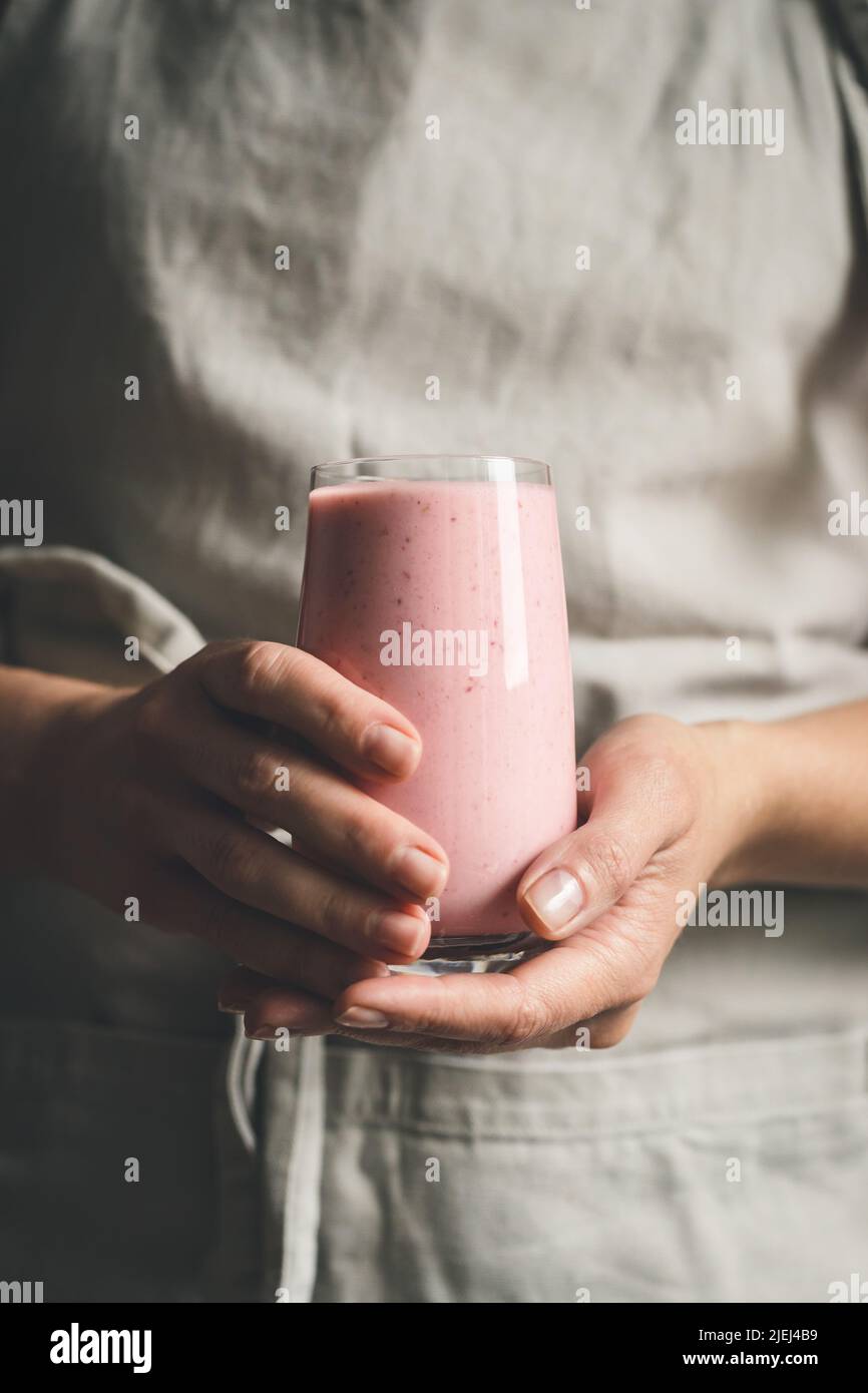 Woman's hands holding strawberry smoothie. Stock Photo