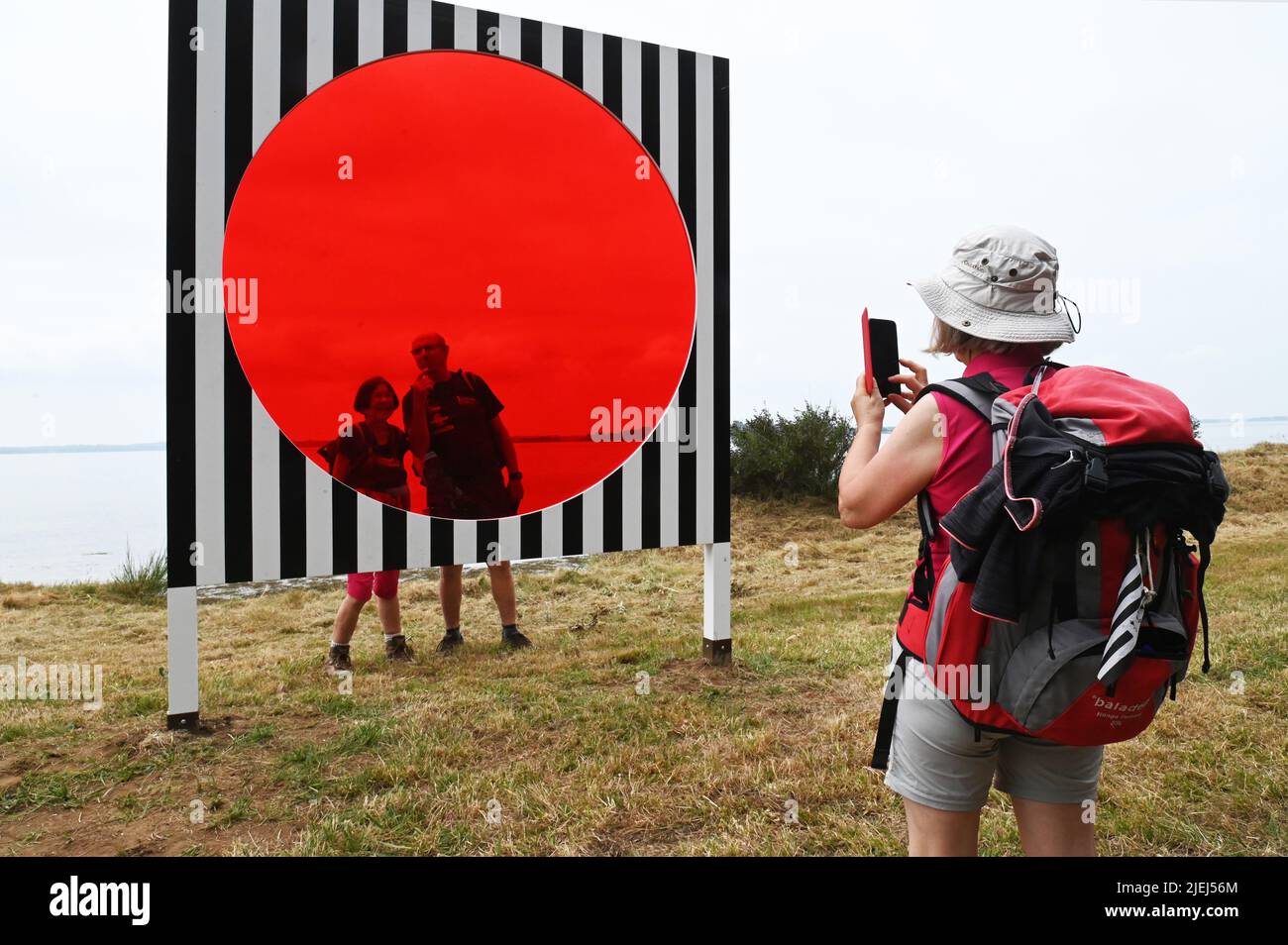 France. Brittany. Morbihan (56) Island of Arz. Bilherve. Group of tourists in front of one of the works of the ephemeral exhibition 'Au detour des rou Stock Photo