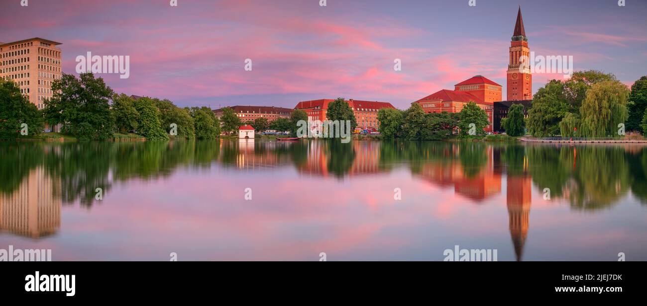 Kiel, Germany. Panoramic cityscape image of downtown Kiel, Germany with Town Hall, Opera House and reflection of the skyline in Small Kiel at sunset. Stock Photo