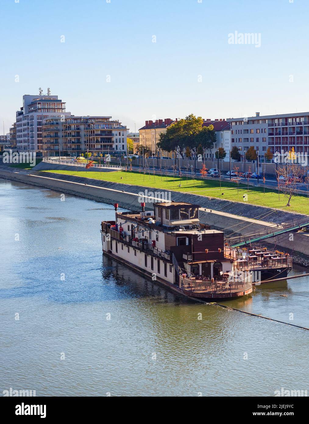 Gyor cirtyscape with ship by Daunbe riverbank in bright sunshine, Hungary Stock Photo