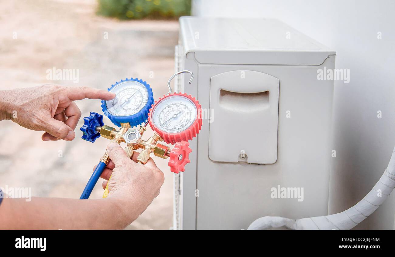 Air conditioner technician checking air conditioner operation Stock