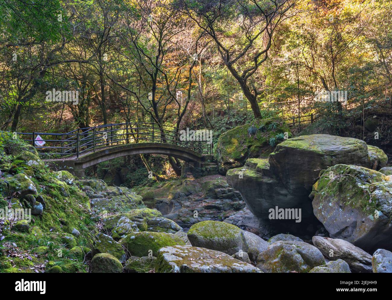 kyushu, japan - december 10 2021: The Todoroki bridge of Isahaya surrounded by lush greenery and rocks along the Sakai river of Taradake Prefectural N Stock Photo