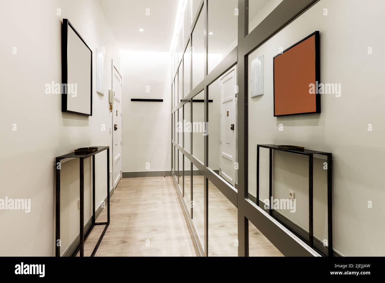 Narrow hallway in a home with an industrialstyle sideboard, white