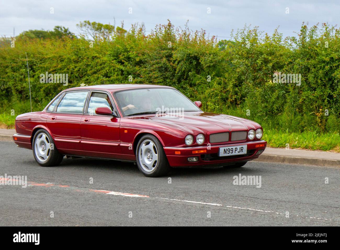 1996, 90s, nineties Red British Jaguar XJR Auto V6 S/C SWB 3980cc supercharged petrol saloon; en-route to Hoghton Tower for the Supercar Summer Showtime car meet which is organised by Great British Motor Shows in Preston, UK Stock Photo