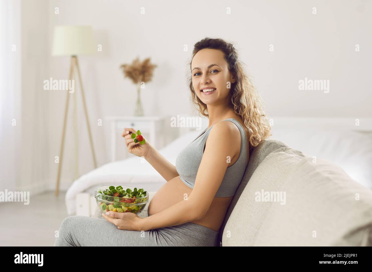 Smiling pregnant woman enjoy tasty vegetable lunch Stock Photo