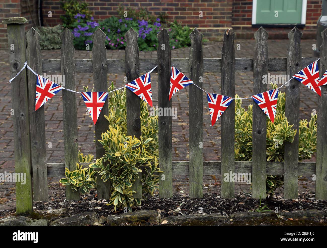 Union Jack Bunting on Fence outside house for Queen Elizabeth II Platinum Jubilee Surrey England Stock Photo
