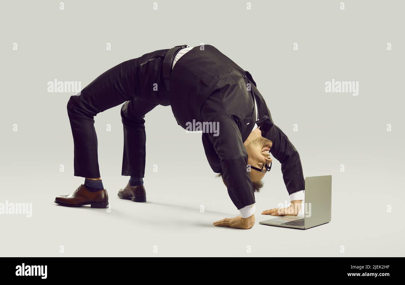 Happy flexible businessman in suit doing yoga while working on his laptop computer Stock Photo