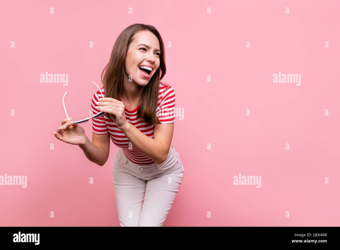 Photo of young girl happy positive smile hold eyeglasses laugh humor joke look empty space isolated over pastel color background Stock Photo