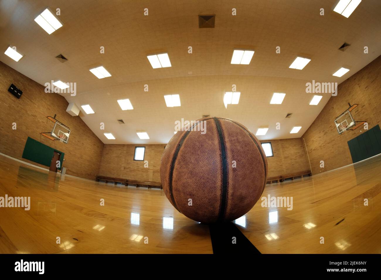 Basketball court with ball hoops rims hardwood floor and lights for