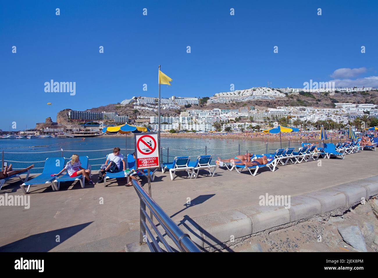 Tourists sunbathing on the pier of Puerto Rico, Grand Canary, Canary islands, Spain, Europe Stock Photo