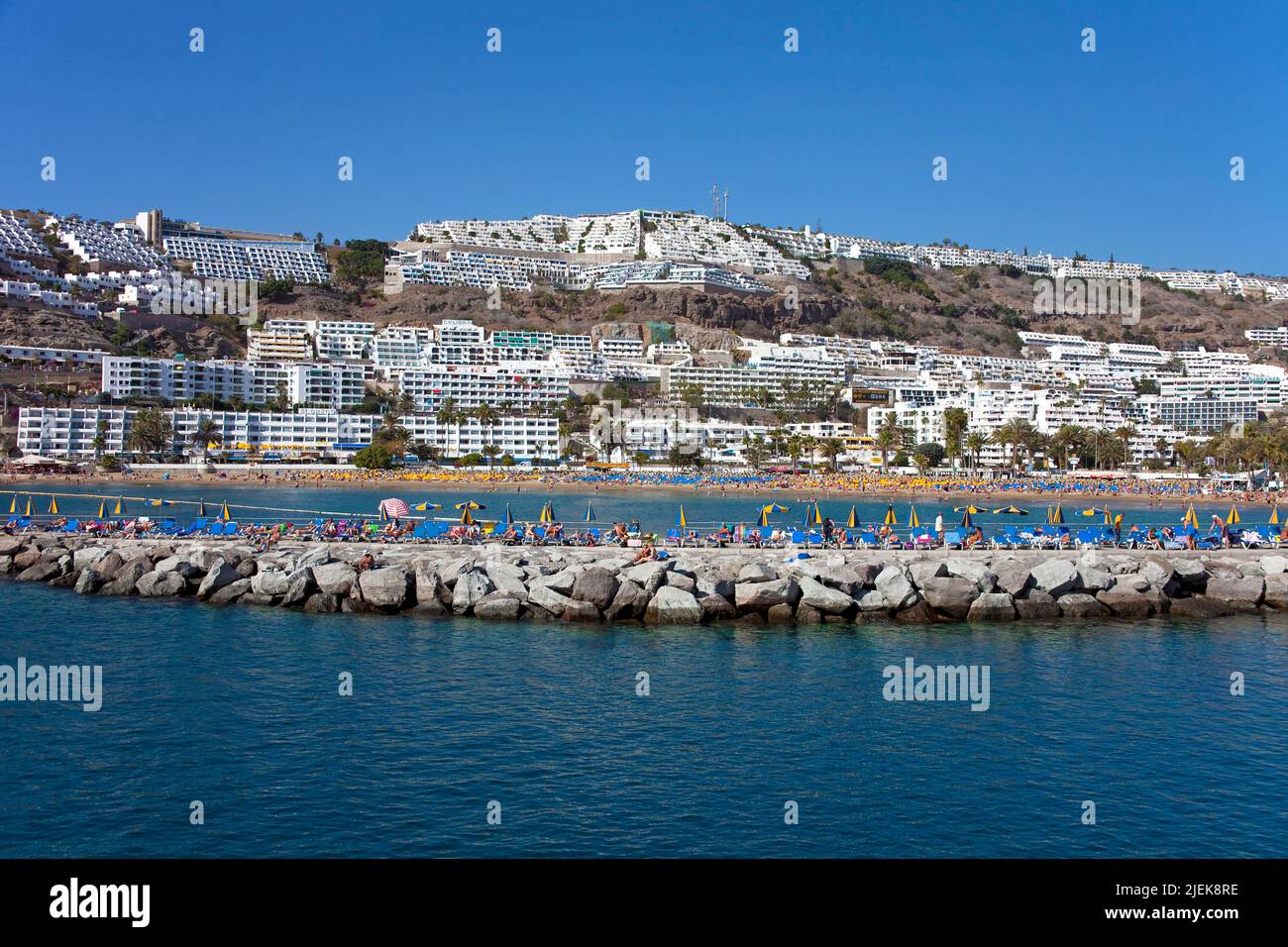 Tourists sunbathing on the pier of Puerto Rico, Grand Canary, Canary islands, Spain, Europe Stock Photo