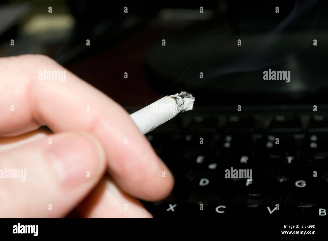 smoking and working on laptop computer Stock Photo