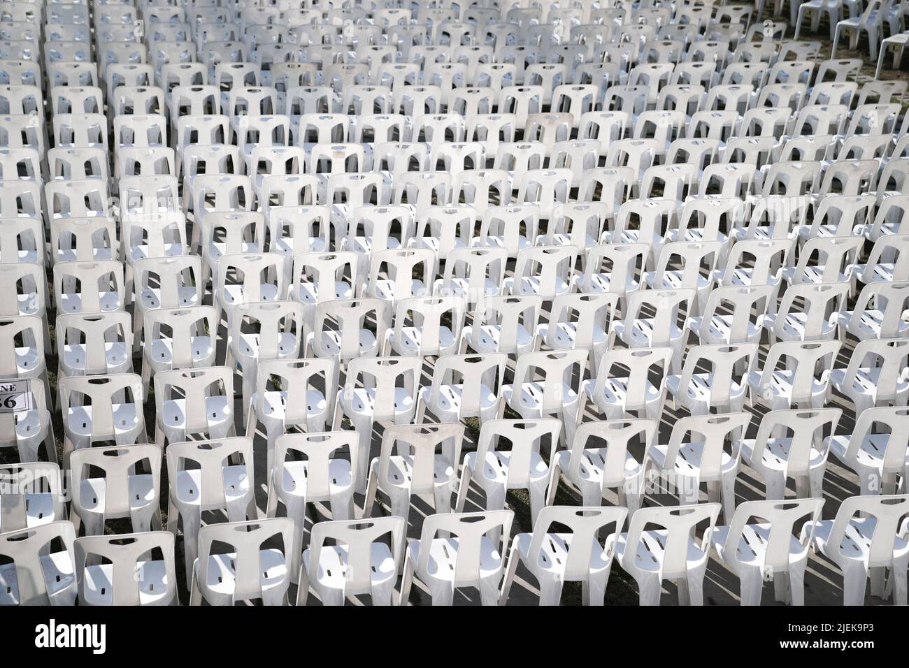 Many white plastic chairs were set up in a square area with the row and