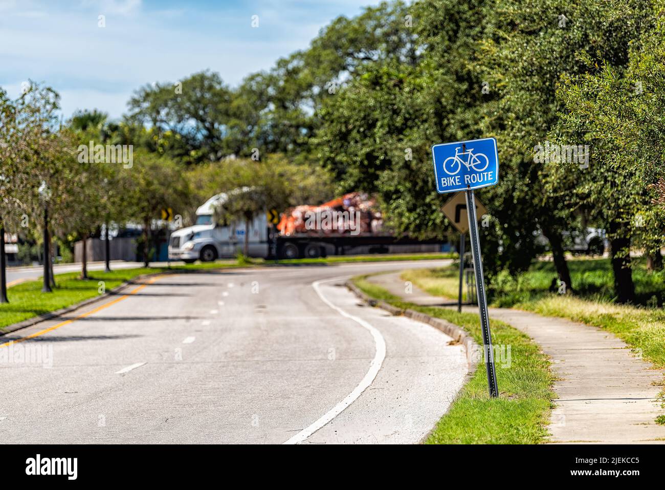 Tarpon Springs, Florida Greek town empty road street with blue sign for bike lane route for bicycles and truck in background on sunny summer day Stock Photo