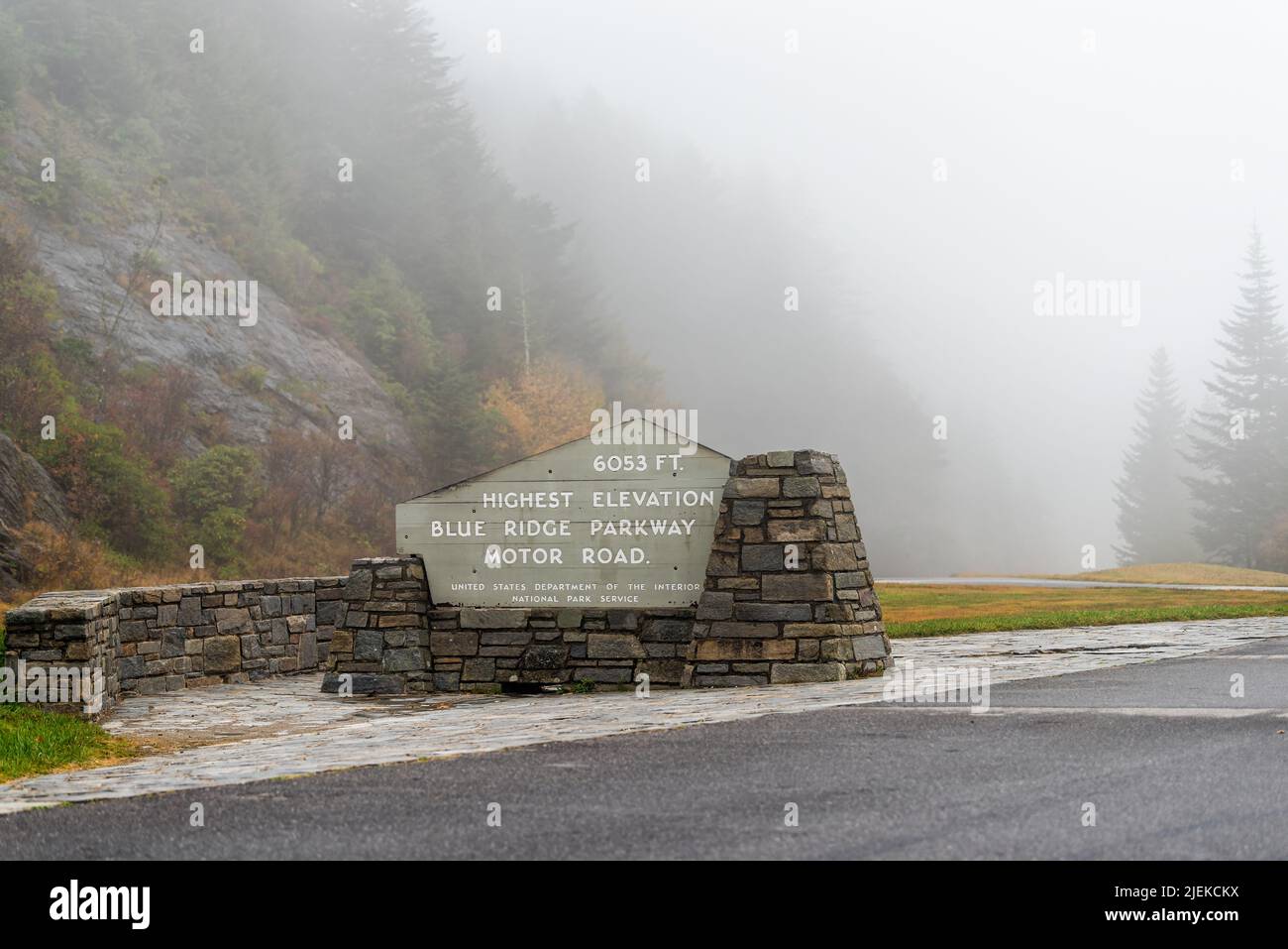 Sign on overlook on Blue Ridge mountains parkway in North Carolina with mist fog on cloudy day and fall colorful foliage for highest elevation at 6053 Stock Photo
