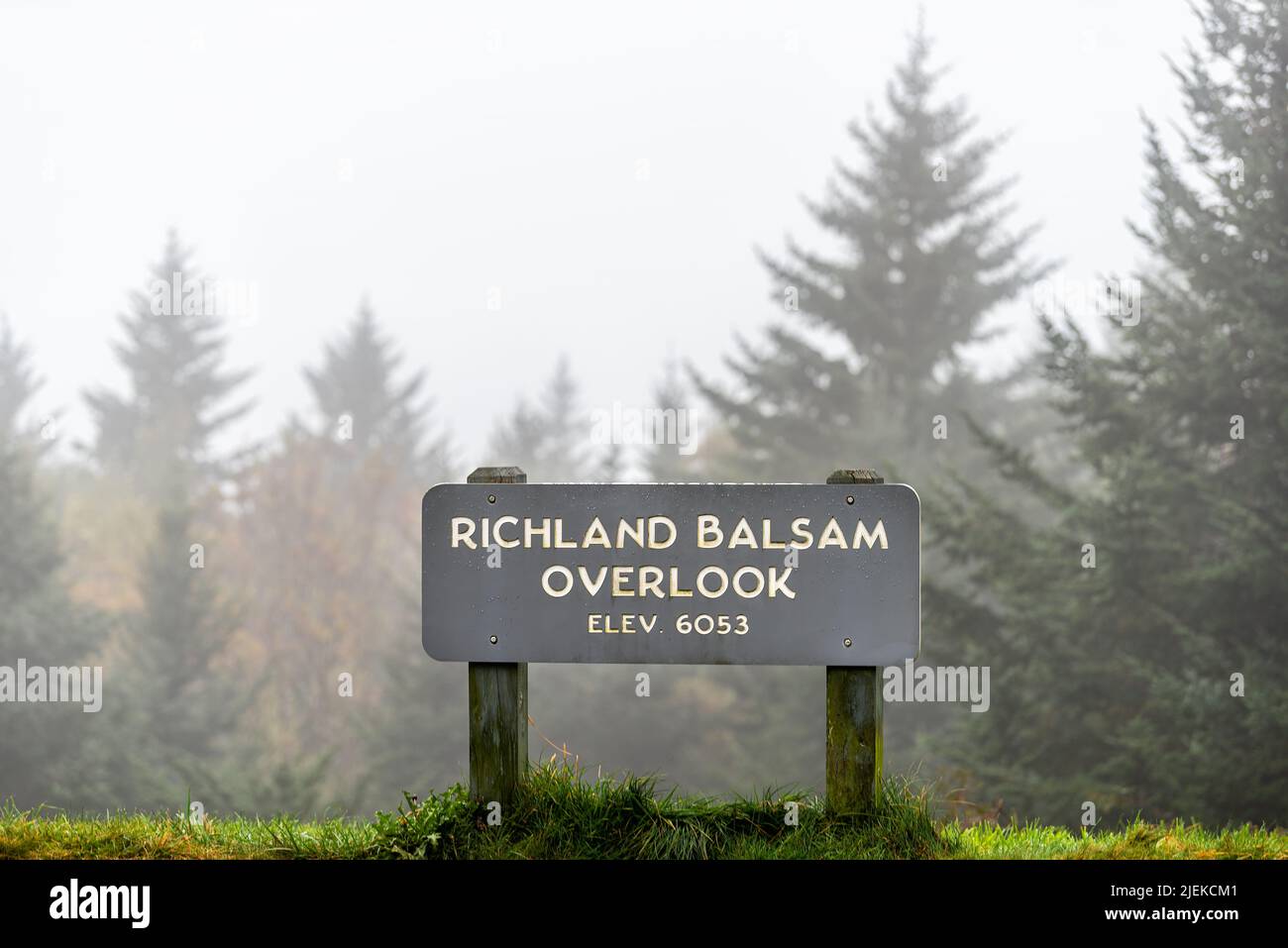 Sign on Richland Balsam overlook on Blue Ridge mountains parkway in North Carolina with mist fog spruce coniferous trees and highest elevation at 6053 Stock Photo